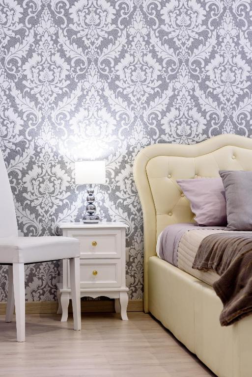 a bedroom with a bed and a side table with a lamp at Saint Peter Cozy Apartment in Rome