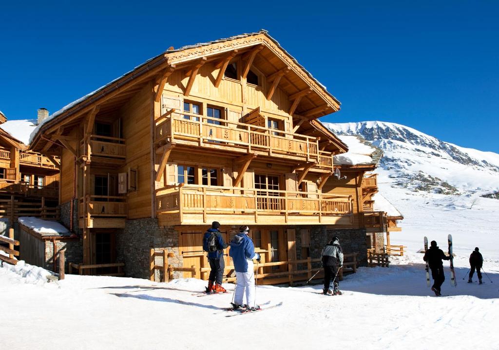 a group of people standing outside of a ski lodge at Madame Vacances Chalet Marmotte in LʼHuez