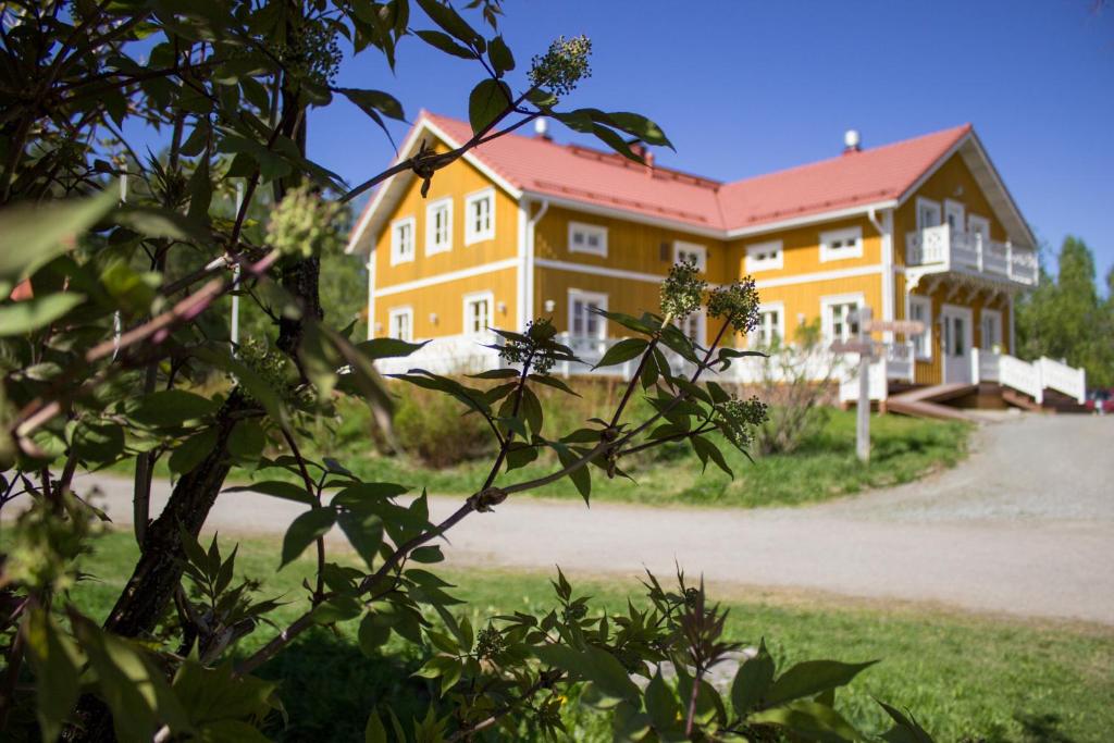 VuonislahtiにあるHerranniemi Guesthouseの赤い屋根の大きな黄色の建物