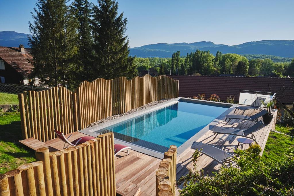 - une piscine dans un jardin avec une clôture en bois dans l'établissement L'Orée de la Chambotte, à Chindrieux