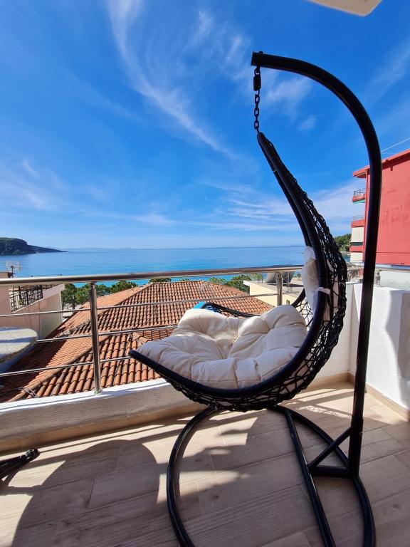 a hammock on a balcony with a view of the ocean at Himara 28 Hotel in Himare