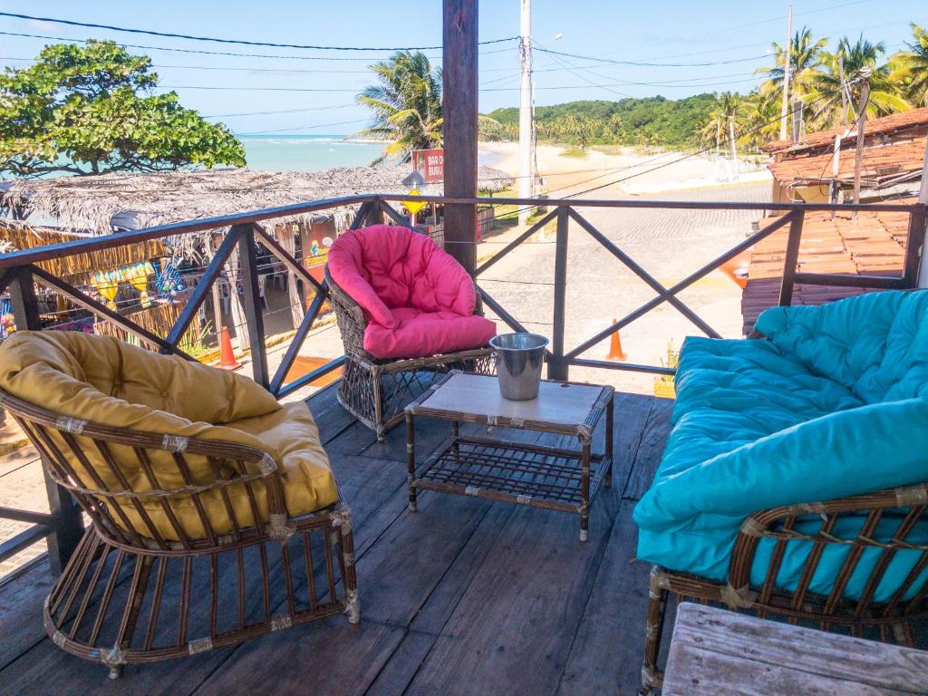two chairs and a table on a balcony with the beach at Verano House BF in Baía Formosa