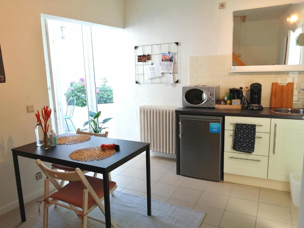 a kitchen with a black table and a counter top at Studio with terrace in 17th century house in Bruges