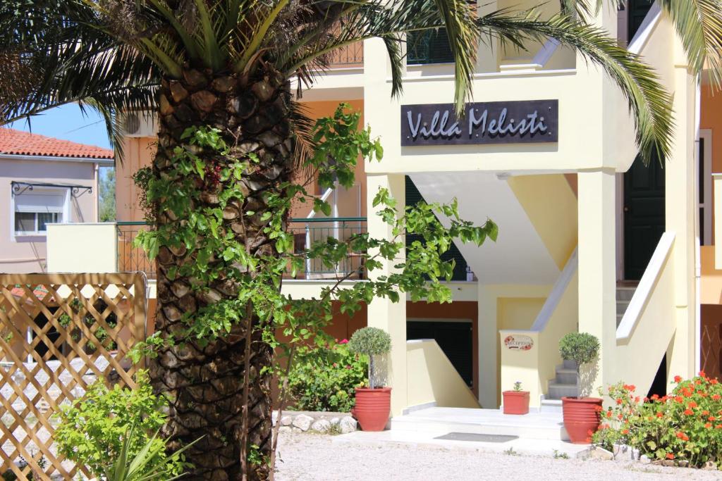 a palm tree in front of a building at Villa Melisti in Tsoukalades