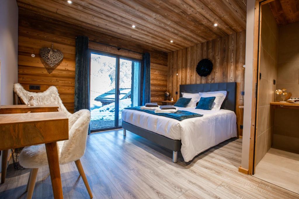 a bedroom with a bed and a desk and a window at Les Mazots des Fées in Morzine