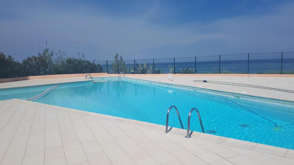a swimming pool with a view of the ocean at Magnifique Studio bord de mer numéro 88 in Santa-Lucia-di-Moriani