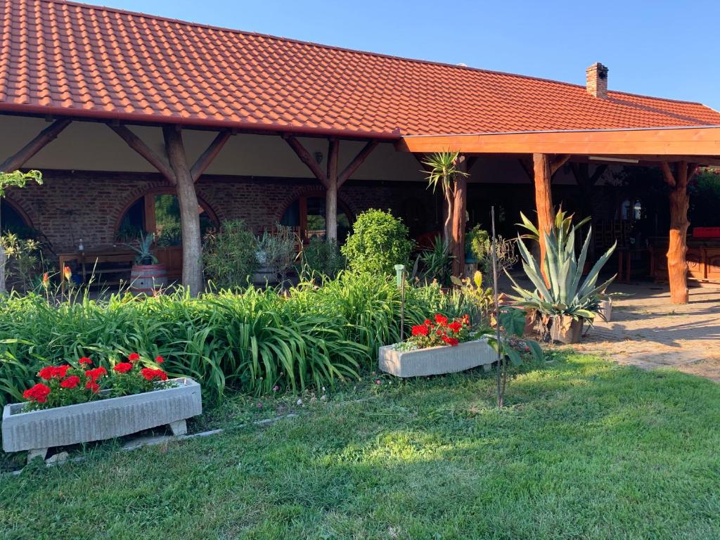 a building with two flower boxes in the grass at Hegedüs Major in Hortobágy