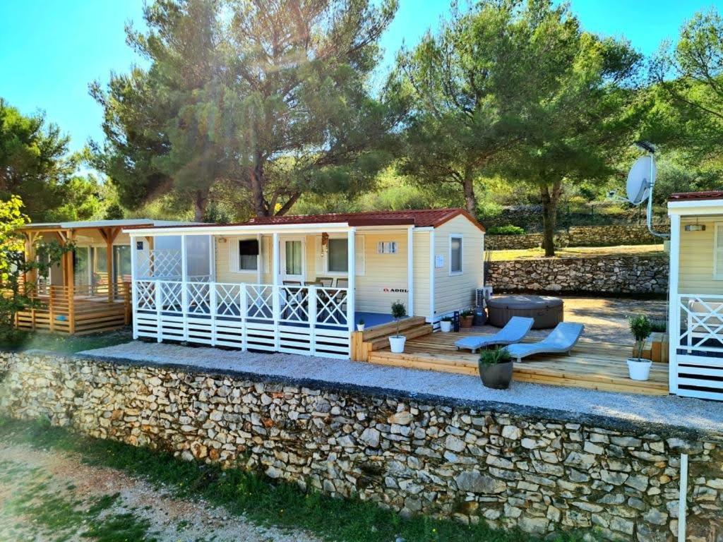 a cottage on the beach with a stone wall at 2Pines House in Jezera