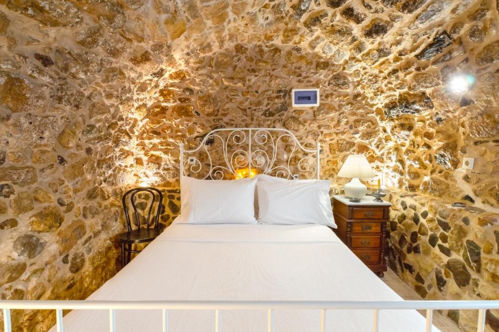 a bedroom with a bed in a stone wall at Diamante Stone House in Sitia