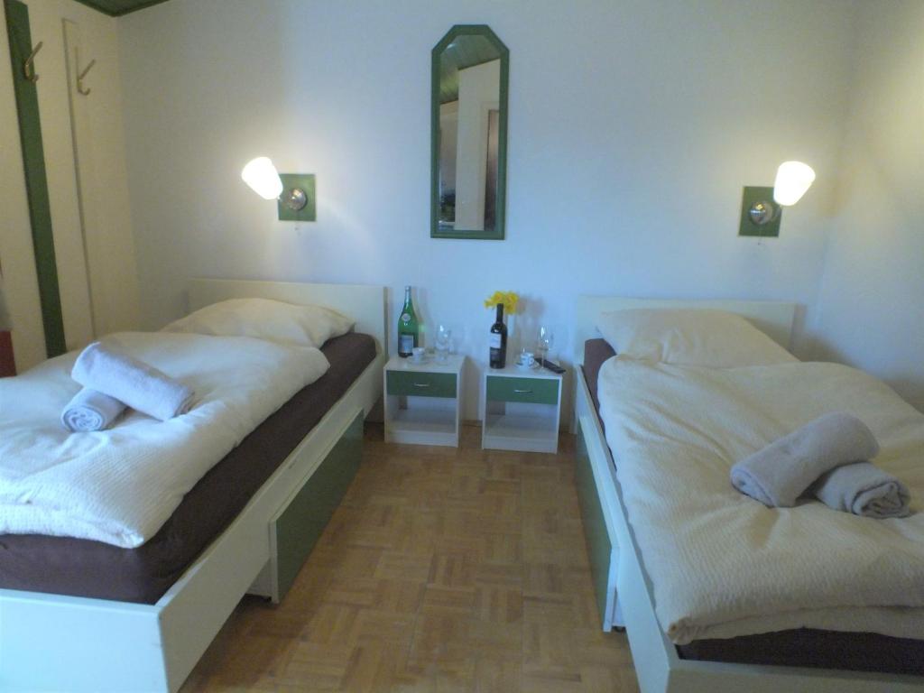 a bedroom with two beds and a mirror on the wall at TrattoriaDonLillo Fewo in Idstein