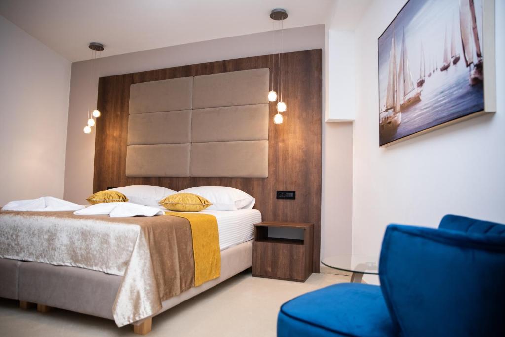 a bedroom with a bed and a blue chair at Hotel Meduza in Senj