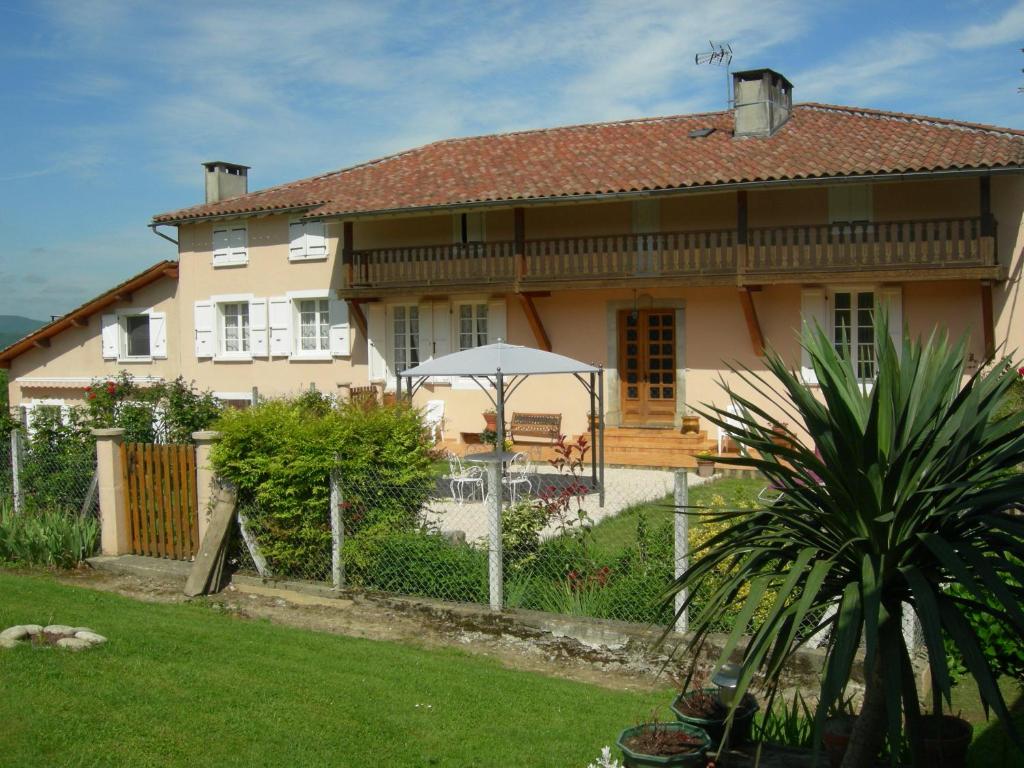 une grande maison avec une clôture devant elle dans l'établissement Le Clos Fleuri, à Caumont