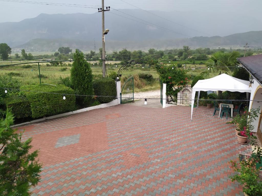 a pavilion with a white tent and a brick patio at HOTEL RESTORANT VIKTORIA in Gjirokastër