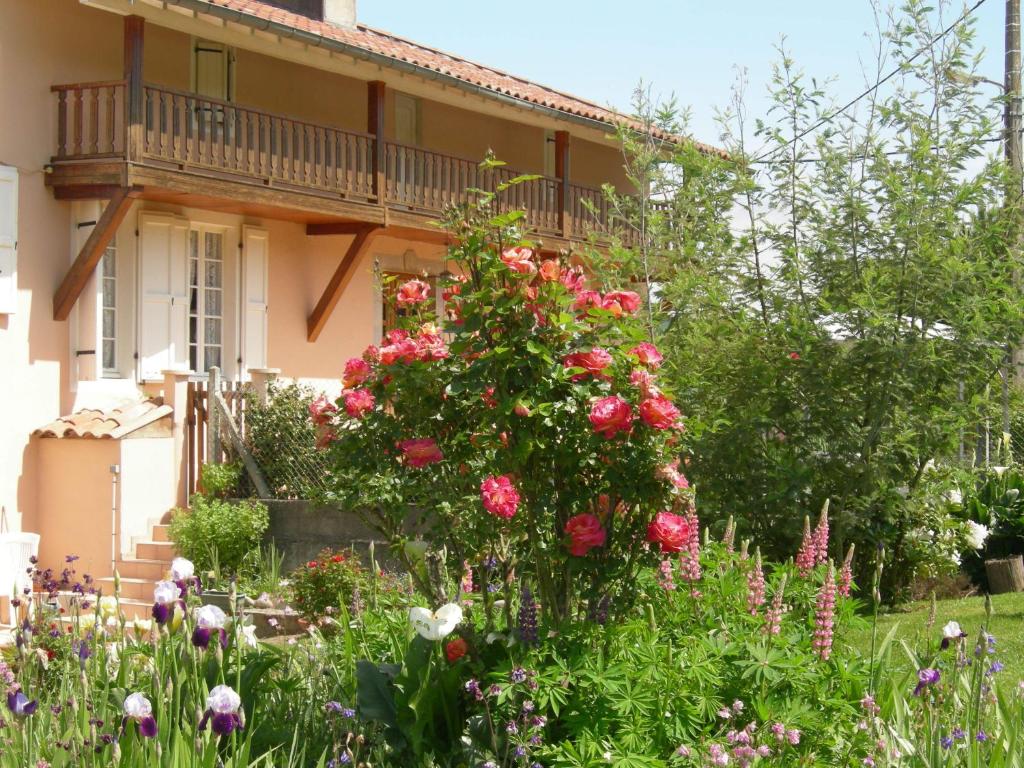 a garden in front of a house with roses at Le Clos Fleuri in Caumont