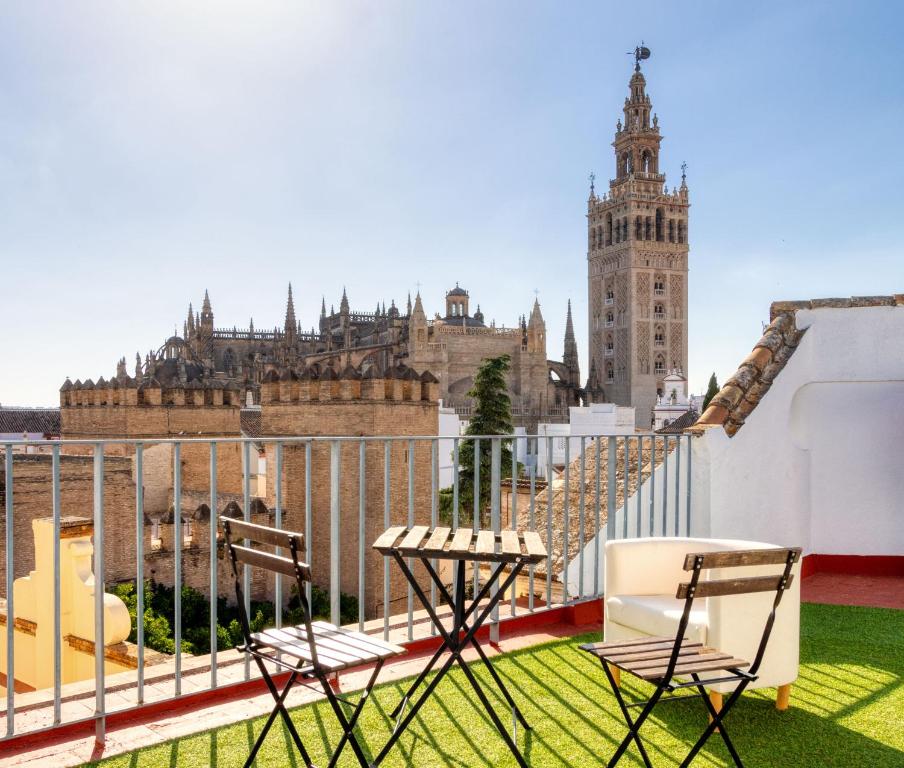 a balcony with two chairs and a view of a city at Alianza Giralda Sky view by Valcambre in Seville