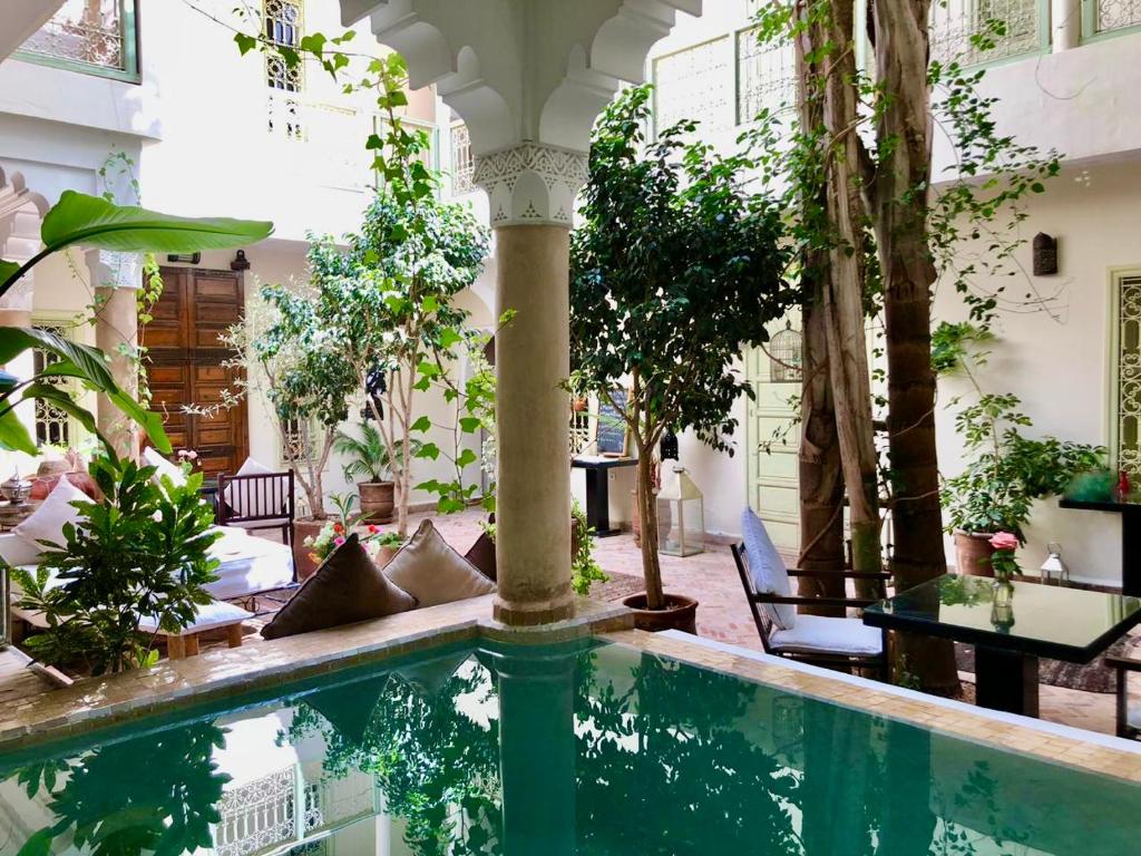 a pool in the middle of a courtyard with trees at Dar Crystal in Marrakesh