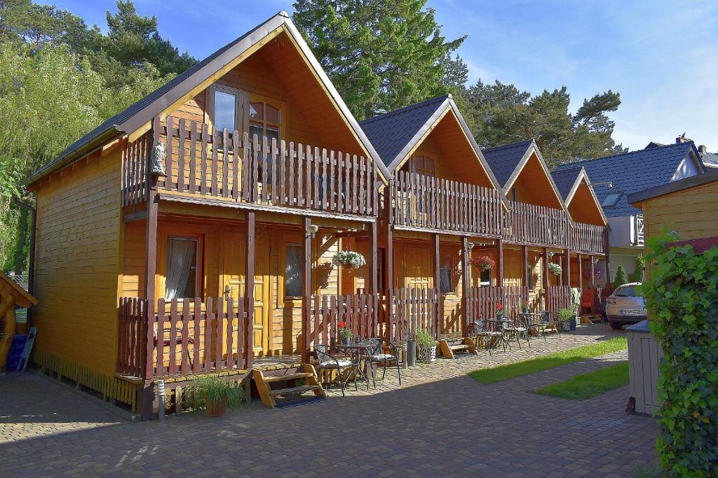 a row of houses with tables and chairs in front of them at Domki ogrzewane Sokół in Władysławowo