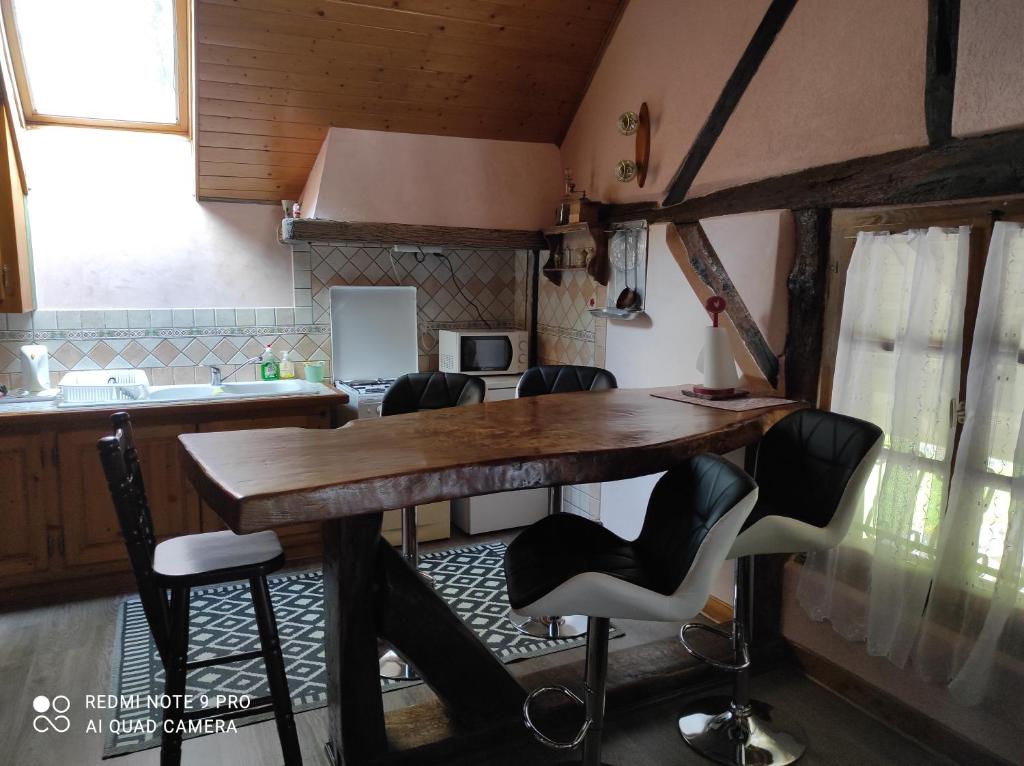 - une cuisine avec une table en bois et des chaises dans l'établissement Gite de peupliers, à Valdieu