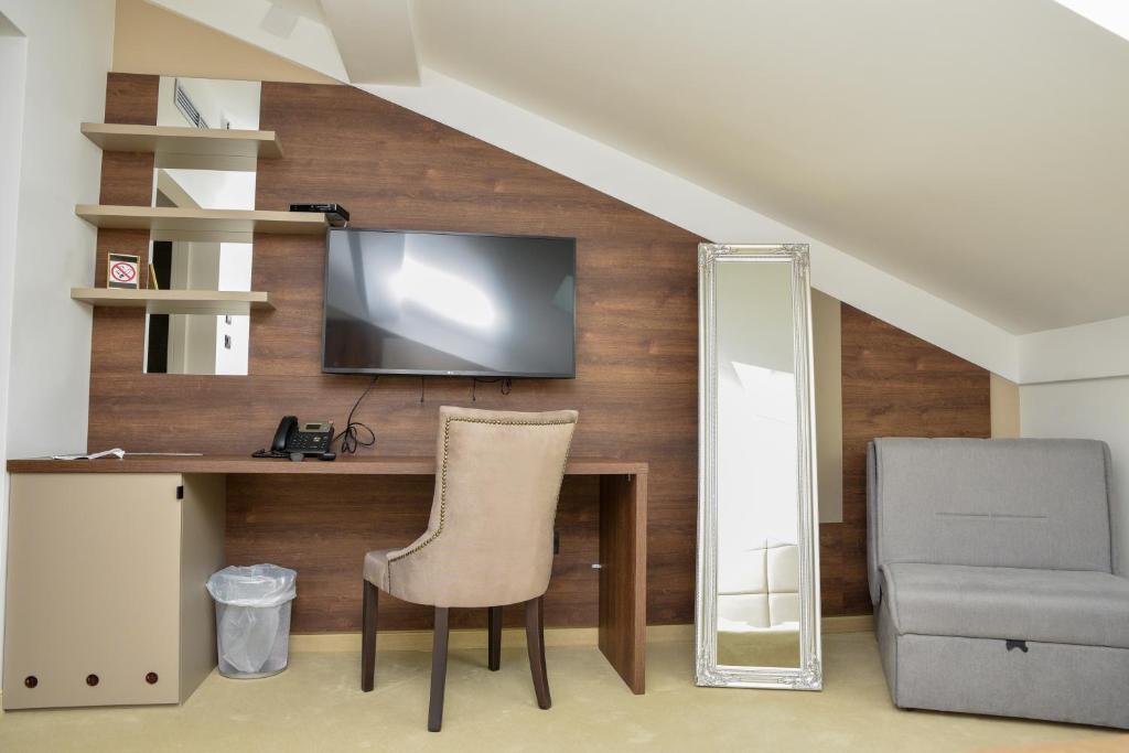 a room with a desk and a chair and a television at Hotel Meduza in Senj