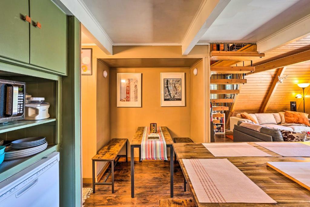 a kitchen and living room with a table and a couch at Running Springs A-Frame with Deck and Mtn Views! in Running Springs