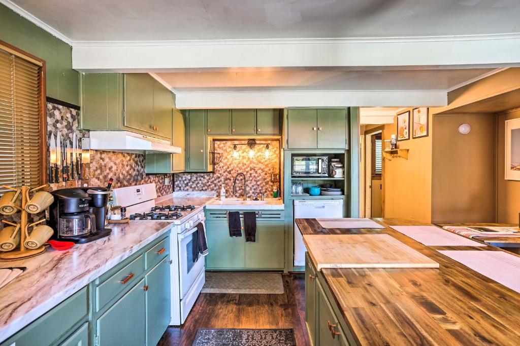a large kitchen with green cabinets and white appliances at Running Springs A-Frame with Deck and Mtn Views! in Running Springs