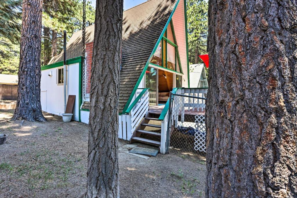 a green and white house with a porch and trees at Running Springs A-Frame with Deck and Mtn Views! in Running Springs