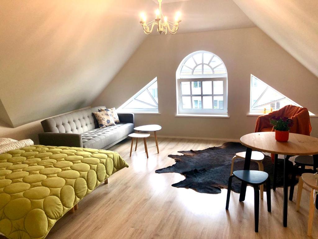 1 dormitorio con cama, sofá y mesa en Captain's House - Kaptenimaja - Apartments en Kärdla