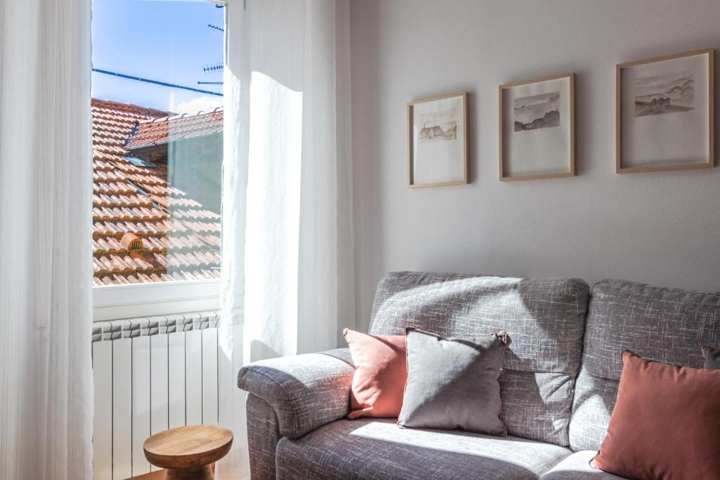 ein Wohnzimmer mit einem Sofa und einem Fenster in der Unterkunft Casa del Borgo "Terra & Fuoco" sul Lago Maggiore in Maccagno Inferiore