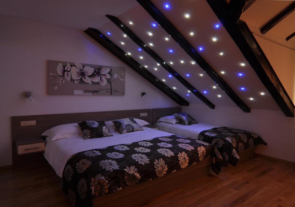 1 dormitorio con 2 camas y luces en el techo en Deluxe Apartments & Rooms Sarella, en Split
