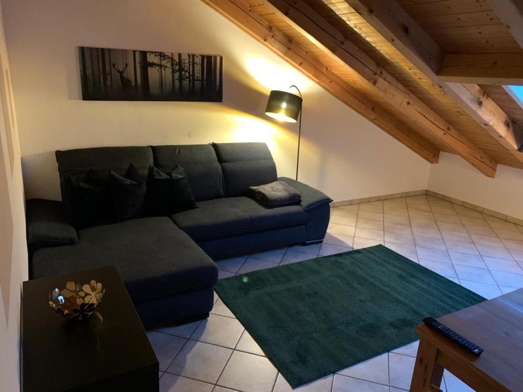 uma sala de estar com um sofá e uma mesa em Ferienwohnung Juliane em Holzkirchen