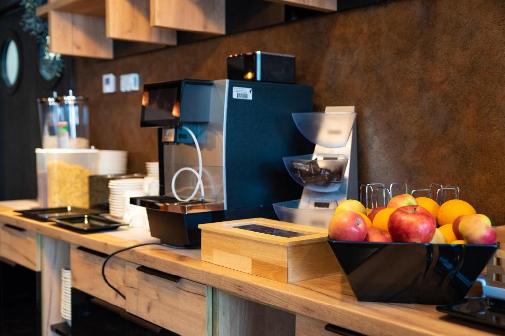 a counter with a bowl of apples and oranges on it at Hotel Meduza in Senj