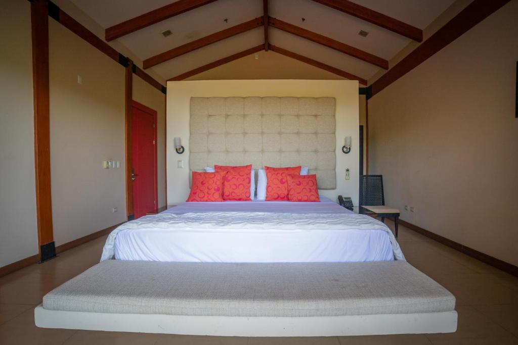 a bedroom with a large white bed with red pillows at Rancho Humo Estancia in Puerto Humo