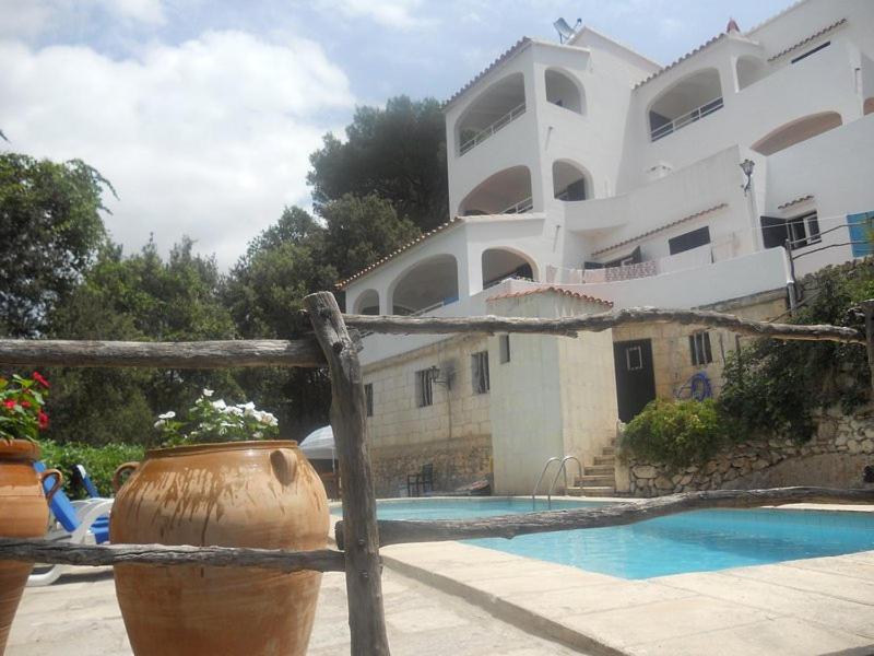un grande edificio con piscina e una casa di 4 Vents Cala Galdana a Cala Galdana