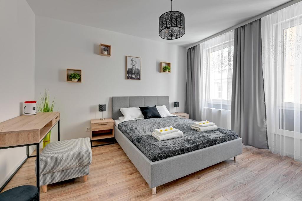 a bedroom with a bed and a desk in it at Apartament Wilcza Gdańsk TriApart in Gdańsk