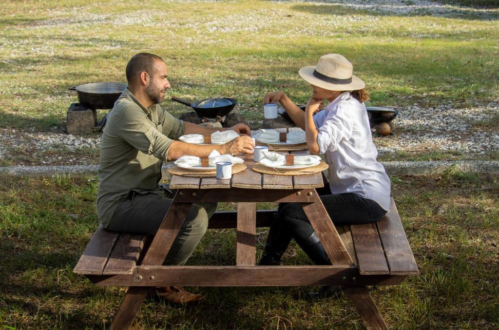 a man and a woman sitting at a picnic table at Rancho Humo Estancia in Puerto Humo