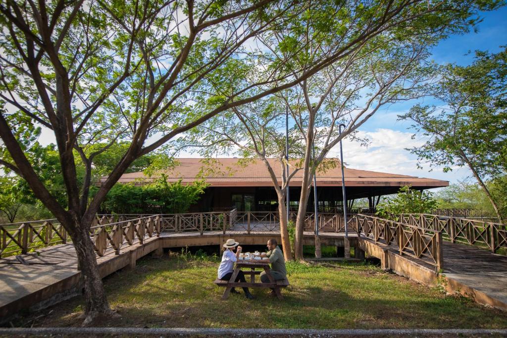 two people sitting at a picnic table in front of a building at Rancho Humo Estancia in Puerto Humo