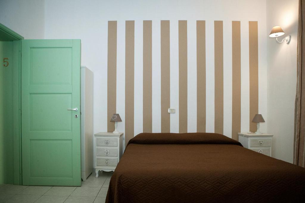 una camera con un letto e una porta verde di B&B La Pineta a Orbetello