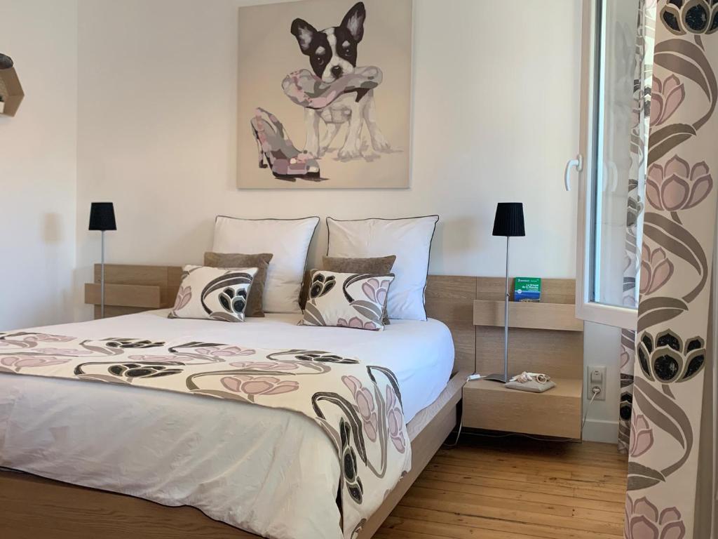 een slaapkamer met een bed met een hondenschildering aan de muur bij L'Annexe, F2, 800 m de la plage in Donville-les-Bains