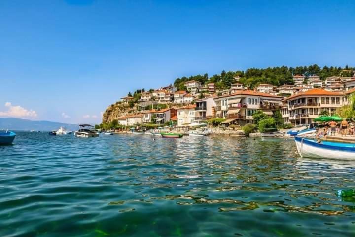 a group of boats in a body of water with houses at Apartman Saraiste in Ohrid