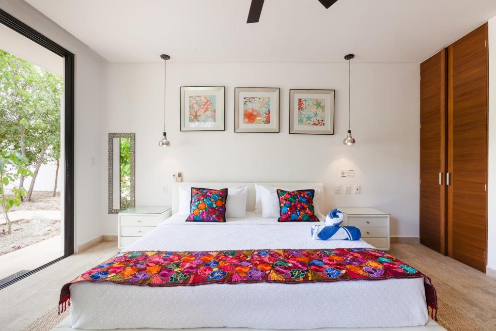 Un dormitorio con una cama grande y una ventana grande. en Mexican style studio with free Spa & Gym access, en Tulum