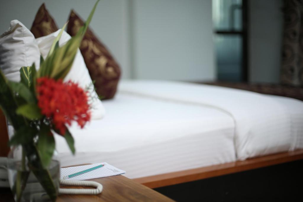 姆萬紮的住宿－Adden Palace Hotel & Conference Centre，睡床旁边的桌子上花瓶