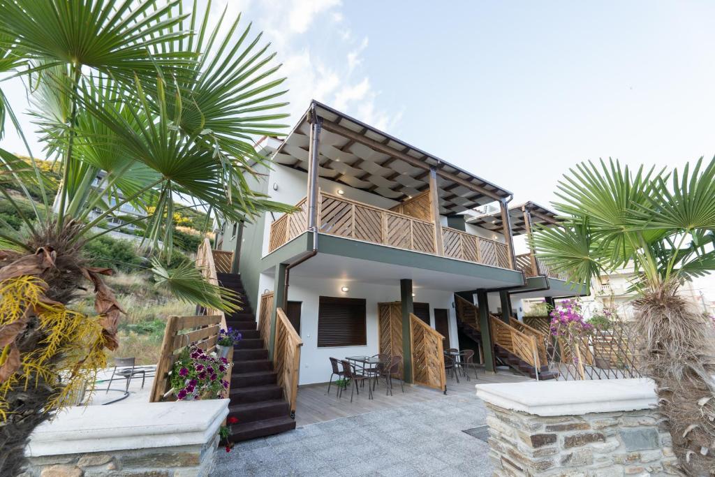 a house with a staircase and palm trees at MAD'S Villas in Néa Péramos