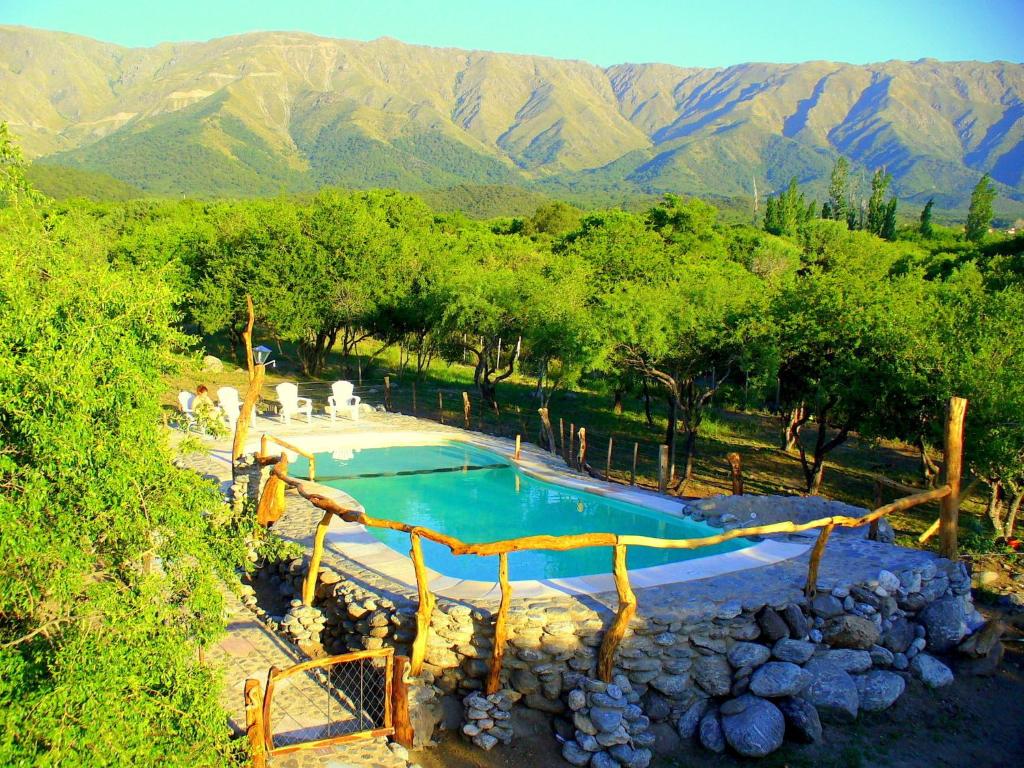 a swimming pool with mountains in the background at Cabañas en Piedras Maia in Merlo