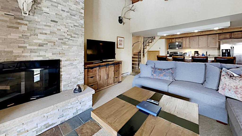 a living room with a blue couch and a fireplace at Timberline Condominiums 1 Bedroom plus Loft Deluxe Unit A3C in Snowmass Village
