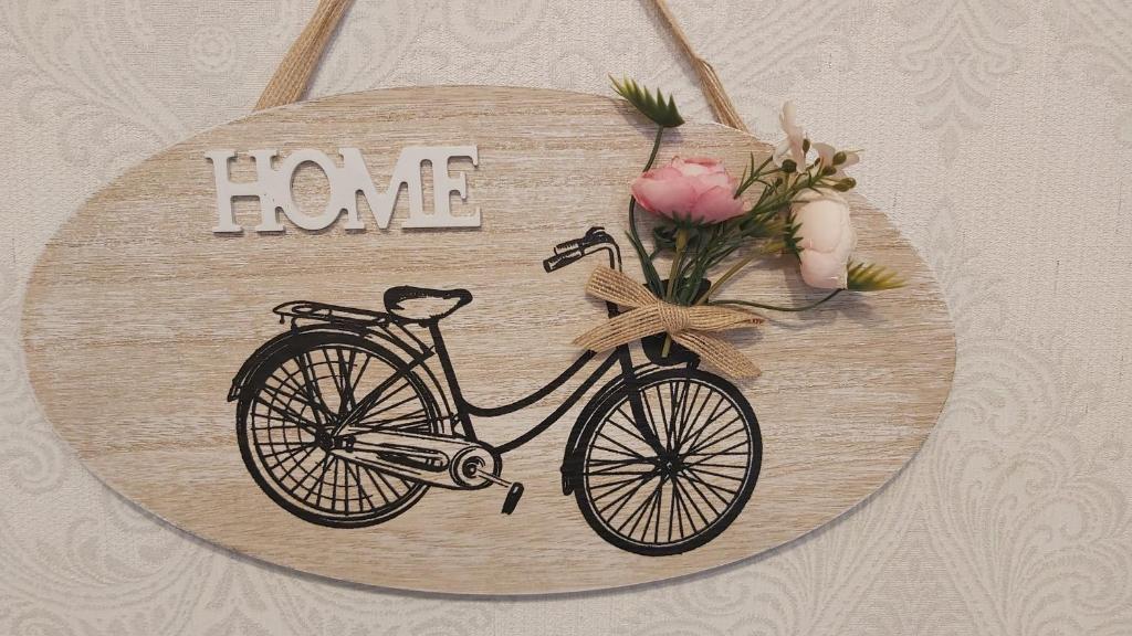 una placa de madera con una bicicleta con la palabra amor en Baia's apartments, en Tiflis
