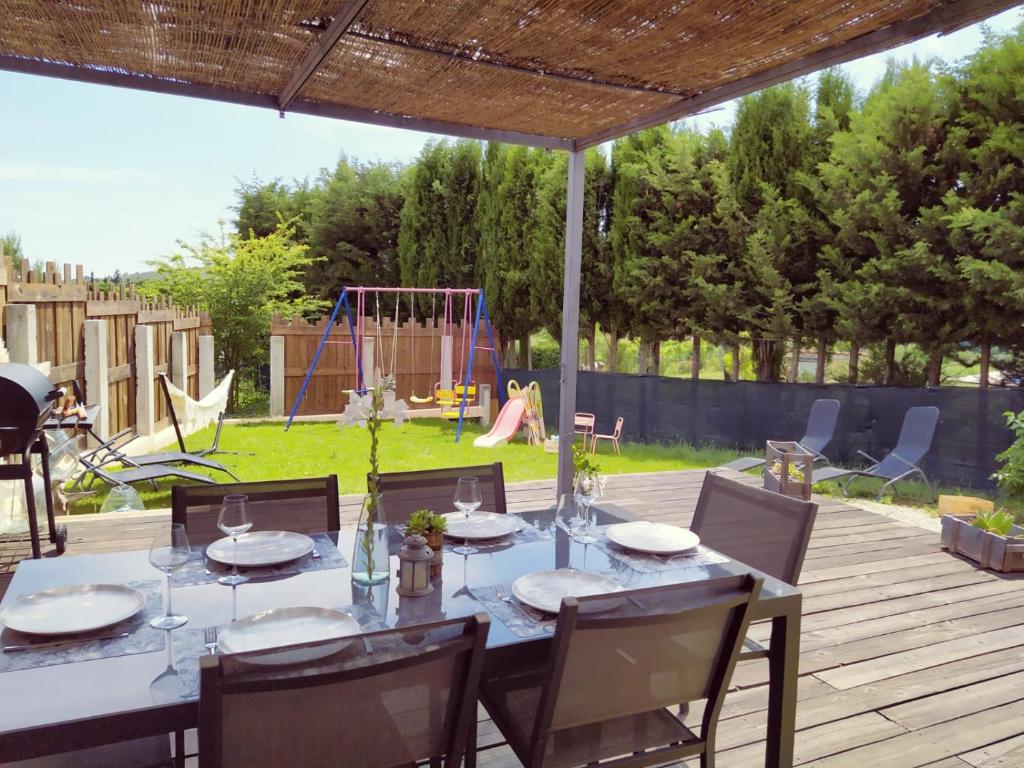 a table and chairs on a patio with a playground at La Bohème in Seillans
