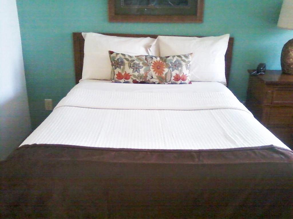 ein Bett mit weißer Bettwäsche und Kissen in einem Schlafzimmer in der Unterkunft Fox Run Association, a VRI resort in Lake Lure