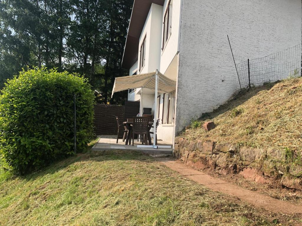 a house with a table and a chair on a porch at LA PETITE MESANGE in Dabo