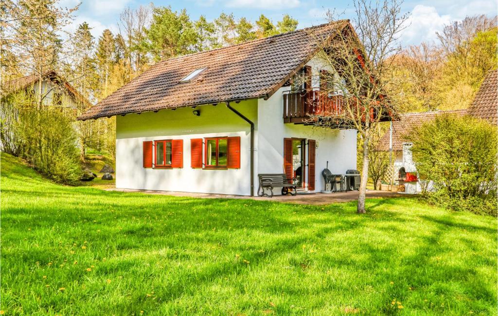 uma pequena casa branca com janelas vermelhas e um quintal em Ferienhaus 4 In Kirchheim em Kirchheim