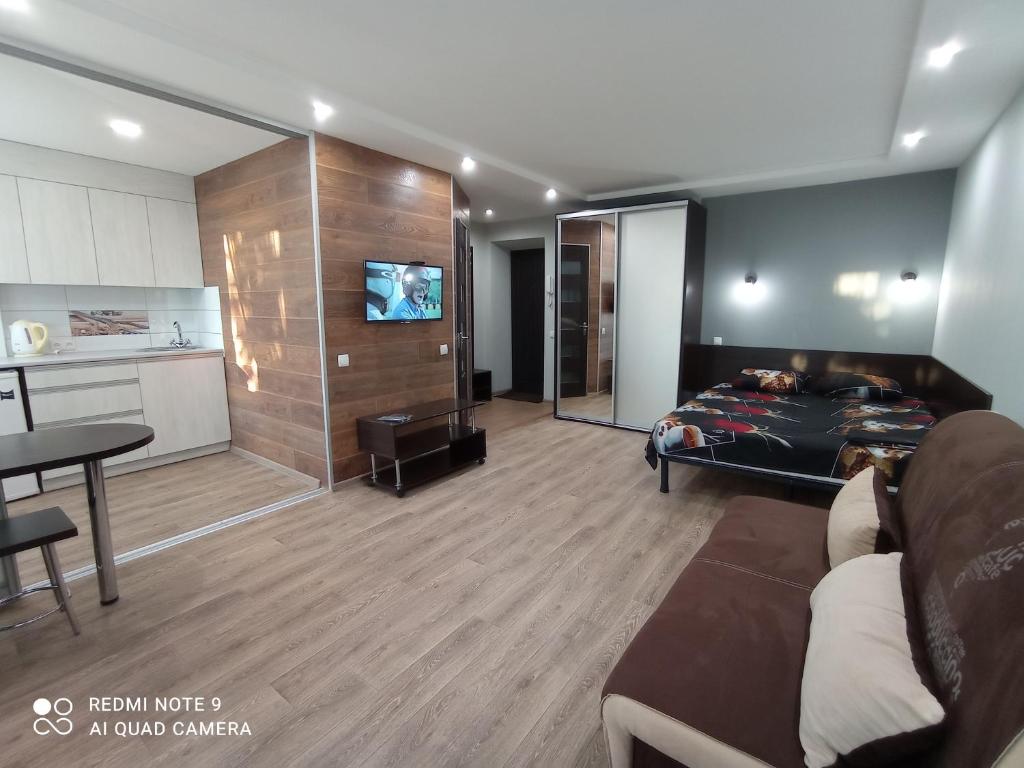 a living room with a couch and a bed and a table at lark apartment in Dnipro